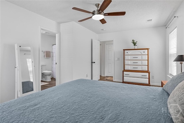 231 Tigers Paw Dr, Pooler, GA 31322 - bedroom featuring multiple windows, wood finished floors, a textured ceiling, connected bathroom, and a ceiling fan