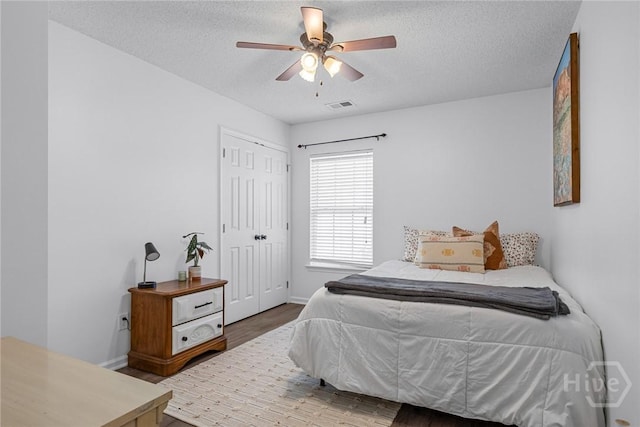 231 Tigers Paw Dr, Pooler, GA 31322 - bedroom with wood finished floors, a textured ceiling, baseboards, a closet, and a ceiling fan