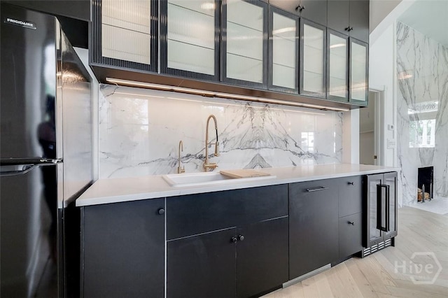 316 W 38th St, Savannah, GA 31401 - kitchen featuring freestanding refrigerator, beverage cooler, a sink, tasteful backsplash, and glass insert cabinets