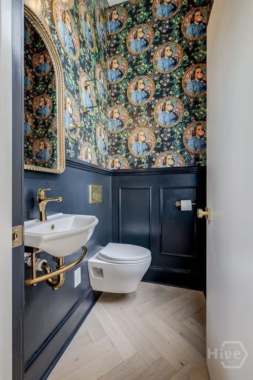 316 W 38th St, Savannah, GA 31401 - half bath featuring a wainscoted wall, toilet, a sink, wallpapered walls, and a decorative wall