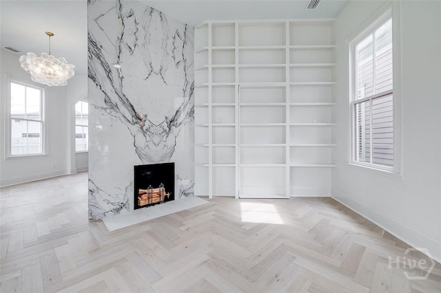 316 W 38th St, Savannah, GA 31401 - unfurnished living room with built in features, a chandelier, a high end fireplace, and baseboards