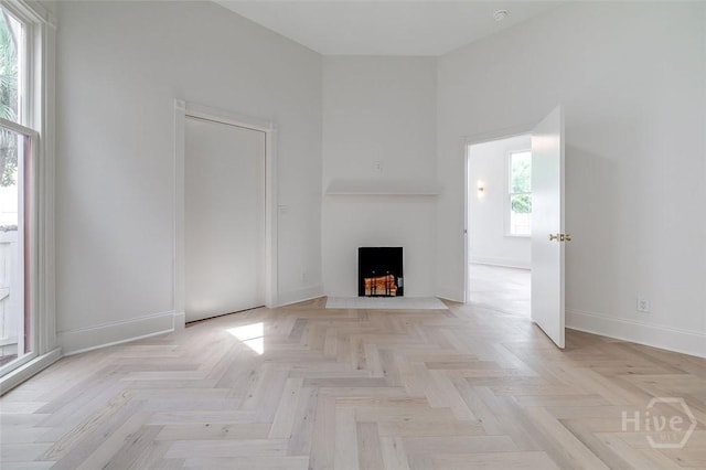 316 W 38th St, Savannah, GA 31401 - unfurnished living room with plenty of natural light, baseboards, a fireplace with flush hearth, and a high ceiling