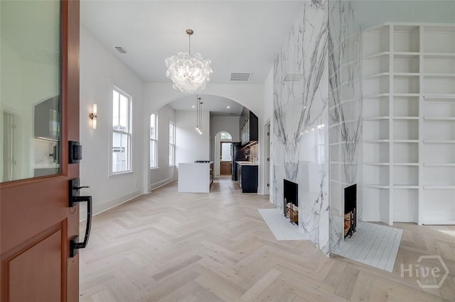 316 W 38th St, Savannah, GA 31401 - foyer entrance with arched walkways, a chandelier, baseboards, and a fireplace