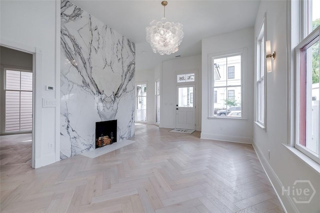 316 W 38th St, Savannah, GA 31401 - unfurnished living room with a chandelier, baseboards, plenty of natural light, and a high end fireplace