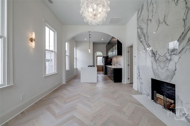 316 W 38th St, Savannah, GA 31401 - unfurnished living room with arched walkways, baseboards, a chandelier, and recessed lighting