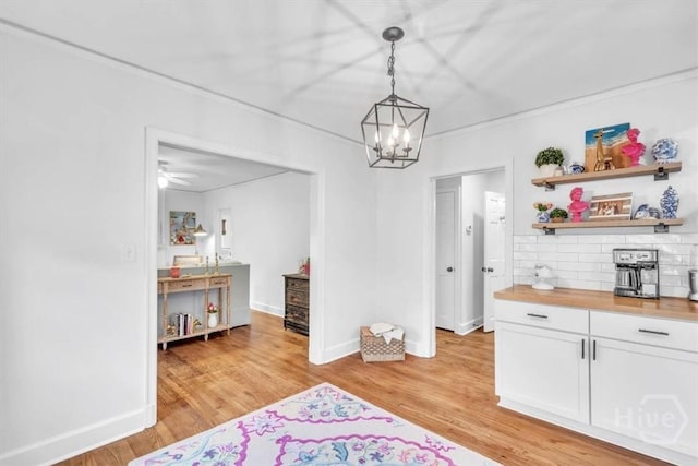 2117 E 42nd St, Savannah, GA 31404 - dining area with light wood-type flooring, a chandelier, baseboards, and crown molding