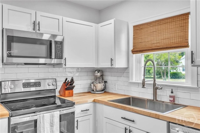 2117 E 42nd St, Savannah, GA 31404 - kitchen with stainless steel appliances, wood counters, a sink, and white cabinets