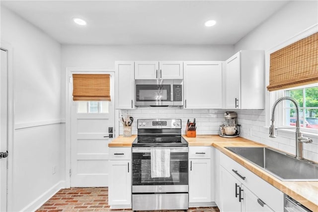 2117 E 42nd St, Savannah, GA 31404 - kitchen featuring appliances with stainless steel finishes, a sink, tasteful backsplash, white cabinets, and recessed lighting