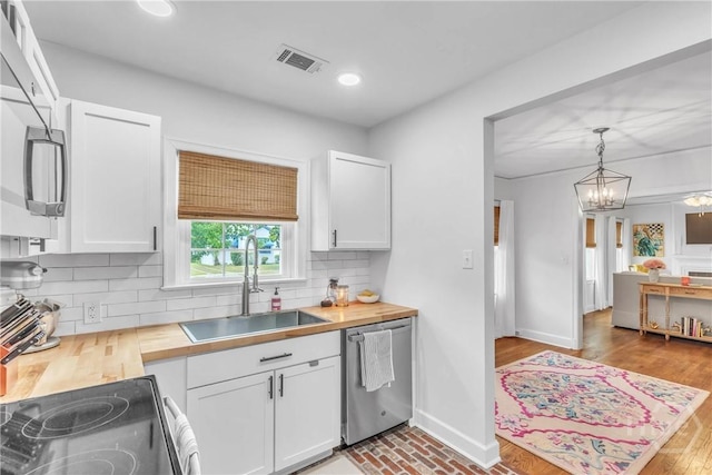 2117 E 42nd St, Savannah, GA 31404 - kitchen featuring stainless steel appliances, a sink, wood counters, white cabinets, and recessed lighting