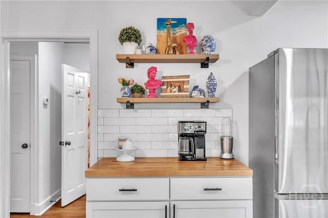 2117 E 42nd St, Savannah, GA 31404 - kitchen view of freestanding refrigerator, open shelves, tasteful backsplash, white cabinetry, and butcher block counters