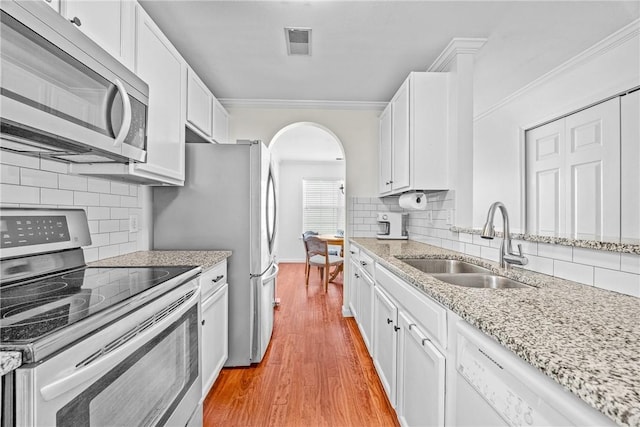 1 Westbourne Way, Savannah, GA 31407 - kitchen with appliances with stainless steel finishes, a sink, arched walkways, ornamental molding, and backsplash