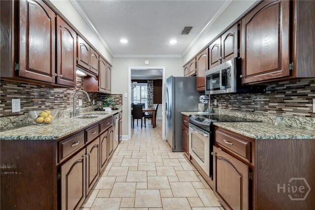 103 W Gazebo Ln, Savannah, GA 31410 - kitchen featuring a sink, appliances with stainless steel finishes, decorative backsplash, light stone finish floors, and light stone counters