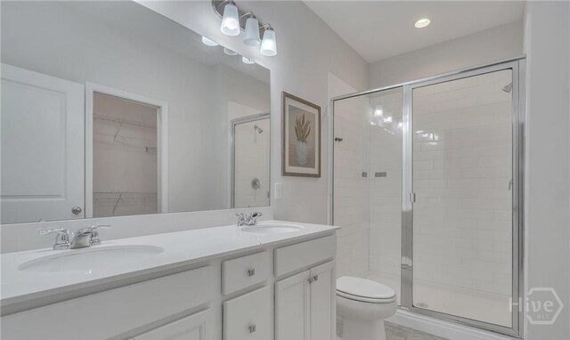 20 Lower Creek Dr, Richmond Hill, GA 31324 - full bathroom featuring a stall shower, double vanity, toilet, and a spacious closet