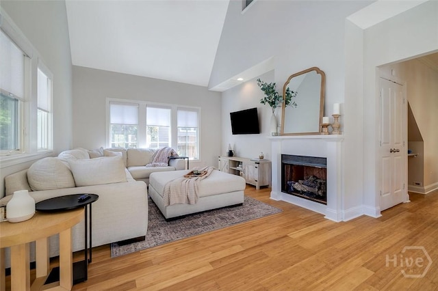115 Daisy Ct, Savannah, GA 31404 - living area with light wood-style flooring, a fireplace, high vaulted ceiling, and baseboards