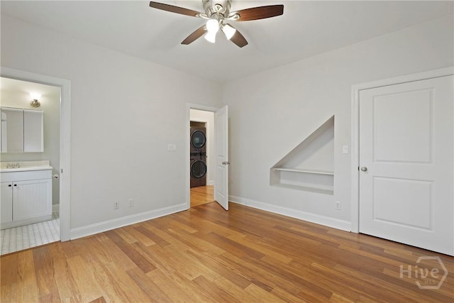 115 Daisy Ct, Savannah, GA 31404 - unfurnished bedroom featuring stacked washing machine and dryer, light wood-type flooring, baseboards, a sink, and ensuite bathroom