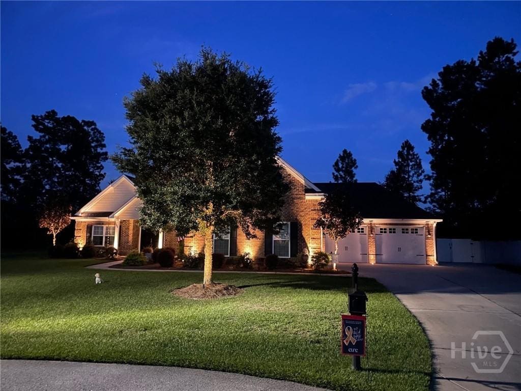 100 Summit Ct, Guyton, GA 31312 - view of front facade with concrete driveway, a front lawn, a garage, and brick siding
