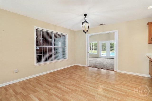 101 Coldbrook Cir, Rincon, GA 31326 - unfurnished dining area with light wood-type flooring, a chandelier, baseboards, and french doors