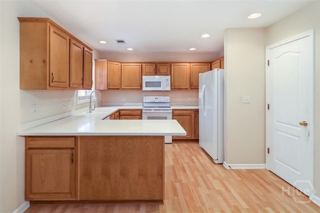 101 Coldbrook Cir, Rincon, GA 31326 - kitchen featuring white appliances, a sink, a peninsula, light countertops, and light wood-type flooring