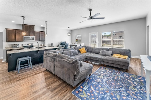 402 Abode Ave, Hinesville, GA 31313 - living area with light wood-style floors, a textured ceiling, ceiling fan, baseboards, and recessed lighting