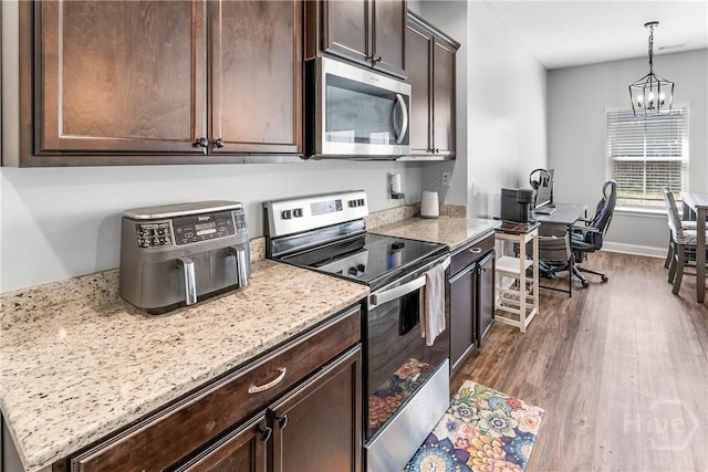 402 Abode Ave, Hinesville, GA 31313 - kitchen with appliances with stainless steel finishes, dark brown cabinets, a chandelier, dark wood-style flooring, and hanging light fixtures