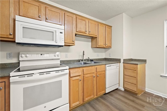 303 Aspen, Rincon, GA 31326 - kitchen featuring white appliances, light wood-style floors, a sink, dark countertops, and a textured ceiling