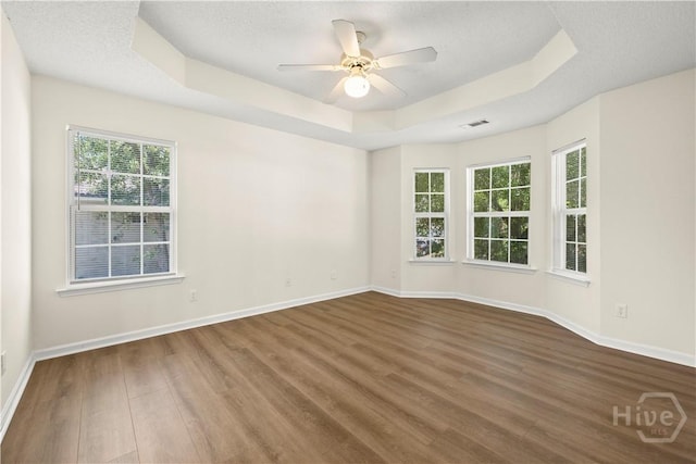 303 Aspen, Rincon, GA 31326 - empty room featuring a tray ceiling, wood finished floors, baseboards, a ceiling fan, and a textured ceiling