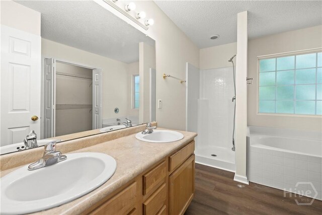 303 Aspen, Rincon, GA 31326 - full bathroom with wood finished floors, a garden tub, double vanity, a shower stall, and a textured ceiling