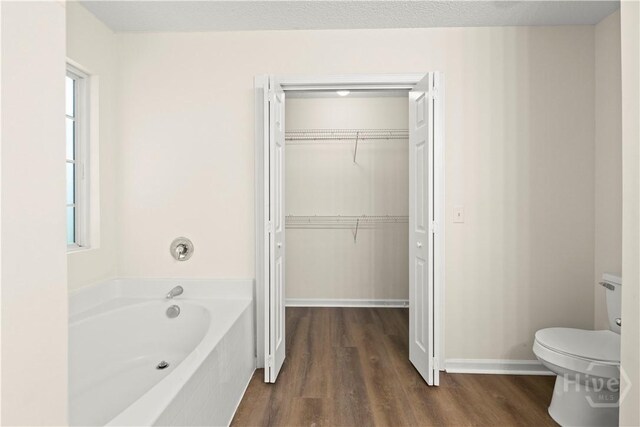 303 Aspen, Rincon, GA 31326 - bathroom with a garden tub, toilet, wood finished floors, and healthy amount of natural light