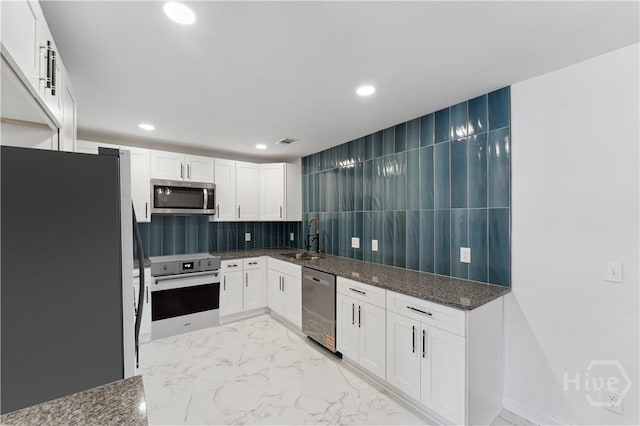 2310 Toussaint Ave, Savannah, GA 31404 - kitchen featuring stainless steel appliances, white cabinets, dark stone counters, a sink, and recessed lighting