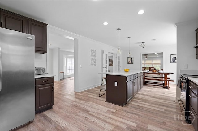 550 Brogdon Rd, Guyton, GA 31312 - kitchen featuring freestanding refrigerator, light countertops, crown molding, a kitchen bar, and light wood-style floors
