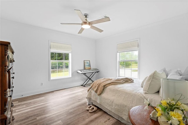 550 Brogdon Rd, Guyton, GA 31312 - bedroom with multiple windows, wood finished floors, crown molding, ceiling fan, and baseboards