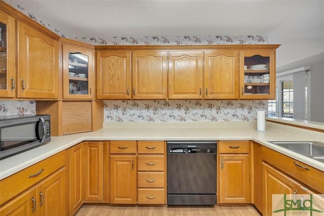 1056 Fiddler Trce, Townsend, GA 31331 - kitchen with dishwashing machine, black microwave, glass insert cabinets, light wood-type flooring, and brown cabinets