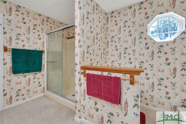 1056 Fiddler Trce, Townsend, GA 31331 - bathroom featuring a shower stall, wallpapered walls, and baseboards