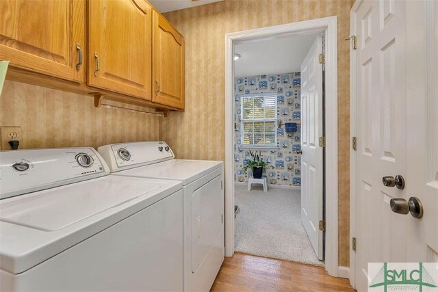 1056 Fiddler Trce, Townsend, GA 31331 - laundry room featuring wallpapered walls, washing machine and clothes dryer, cabinet space, light wood finished floors, and baseboards