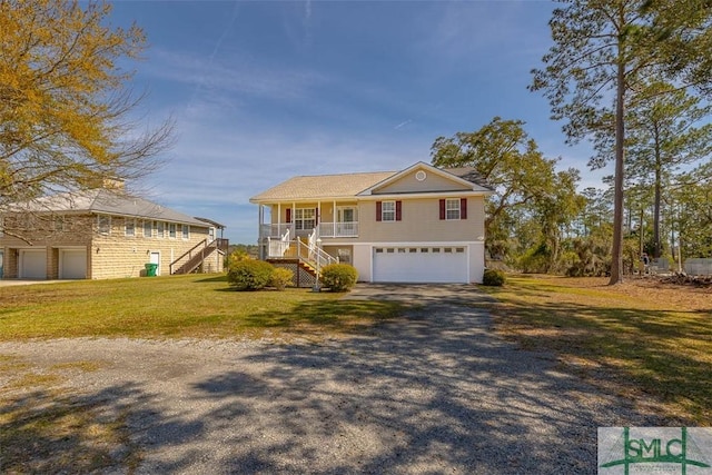 1056 Fiddler Trce, Townsend, GA 31331 - view of front facade featuring stairway, a garage, a porch, driveway, and a front yard