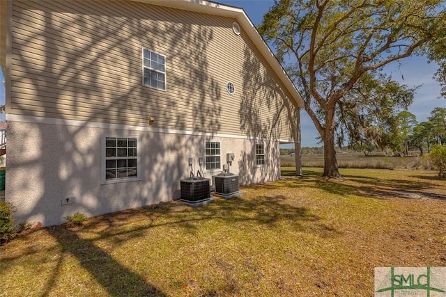 1056 Fiddler Trce, Townsend, GA 31331 - view of home's exterior featuring stucco siding, a lawn, and central AC