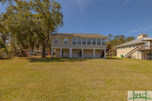 1056 Fiddler Trce, Townsend, GA 31331 - rear view of house with stairs, a yard, and a deck