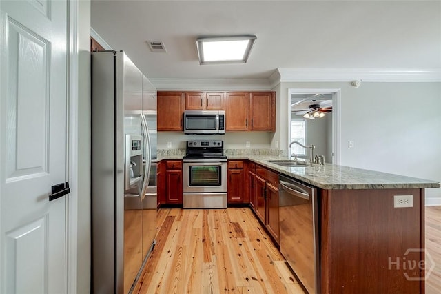 428 Roberts Way, Rincon, GA 31326 - kitchen with stainless steel appliances, a sink, a peninsula, light wood-style flooring, and crown molding