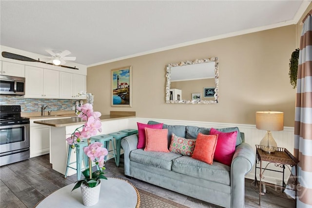1217 Bay St Unit 105B, Tybee Island, GA 31328 - living room with crown molding, dark wood-style flooring, and a wainscoted wall