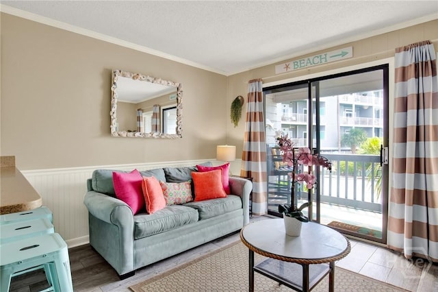 1217 Bay St Unit 105B, Tybee Island, GA 31328 - living area featuring crown molding, a textured ceiling, a wainscoted wall, and wood finished floors