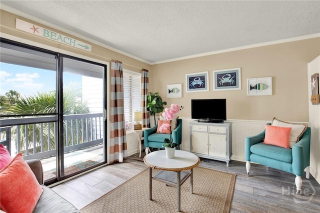 1217 Bay St Unit 105B, Tybee Island, GA 31328 - living area featuring a textured ceiling, wood finished floors, healthy amount of natural light, crown molding, and wainscoting