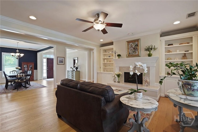 8813 Whitefield Ave, Savannah, GA 31406 - living area with a fireplace, light wood-style floors, a chandelier, a ceiling fan, and ornamental molding