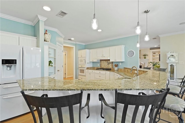8813 Whitefield Ave, Savannah, GA 31406 - kitchen featuring white appliances, a sink, a breakfast bar area, ornamental molding, and a peninsula