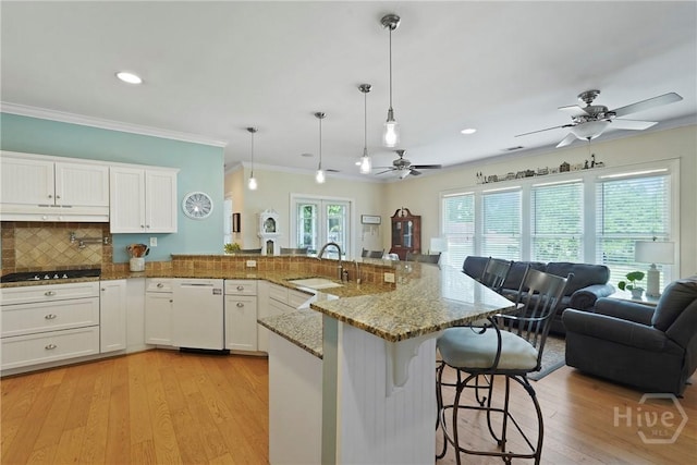 8813 Whitefield Ave, Savannah, GA 31406 - kitchen featuring a sink, white dishwasher, ceiling fan, a breakfast bar area, and crown molding