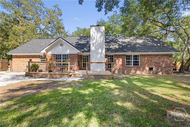 67 Oak Side Ct, Richmond Hill, GA 31324 - view of front of house with brick siding, a chimney, a deck, and roof with shingles