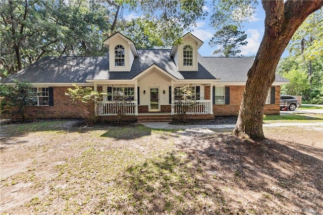 67 Oak Side Ct, Richmond Hill, GA 31324 - cape cod-style house with brick siding, covered porch, and a shingled roof