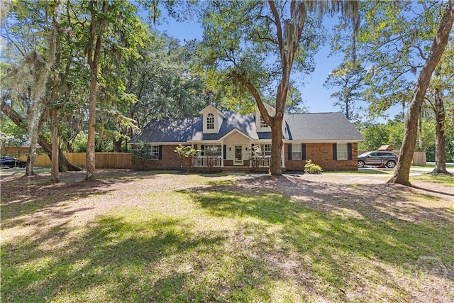 67 Oak Side Ct, Richmond Hill, GA 31324 - cape cod home with a porch and brick siding