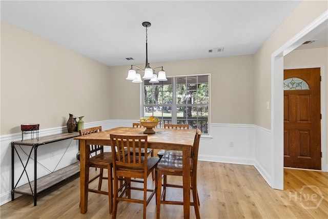 67 Oak Side Ct, Richmond Hill, GA 31324 - dining space with light wood-type flooring, a chandelier, and wainscoting