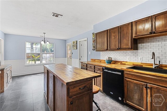 67 Oak Side Ct, Richmond Hill, GA 31324 - kitchen with butcher block countertops, dishwasher, a sink, a wainscoted wall, and a kitchen island