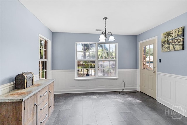 67 Oak Side Ct, Richmond Hill, GA 31324 - unfurnished dining area featuring wainscoting, a chandelier, and dark tile patterned flooring